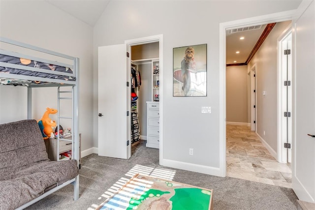 carpeted bedroom with a closet, vaulted ceiling, and ornamental molding