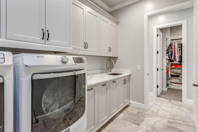 clothes washing area featuring washer and dryer, cabinets, ornamental molding, and sink