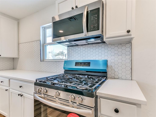 kitchen featuring stainless steel appliances, white cabinets, and tasteful backsplash