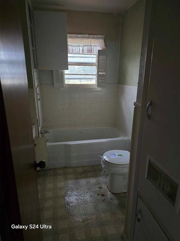 bathroom with a washtub and toilet