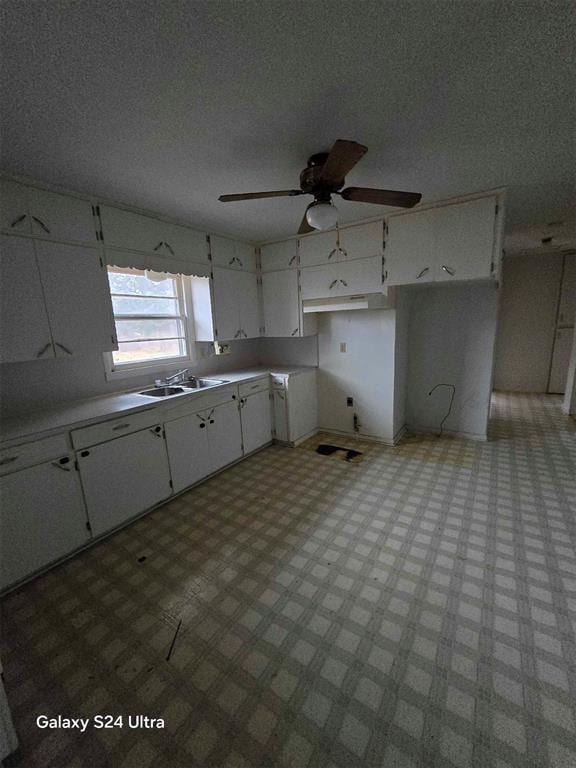 kitchen featuring white cabinetry, sink, ceiling fan, and a textured ceiling