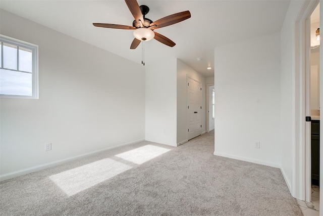 unfurnished room featuring light carpet, ceiling fan, and baseboards