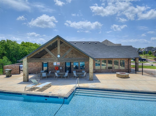 pool featuring fence, a fire pit, and a patio