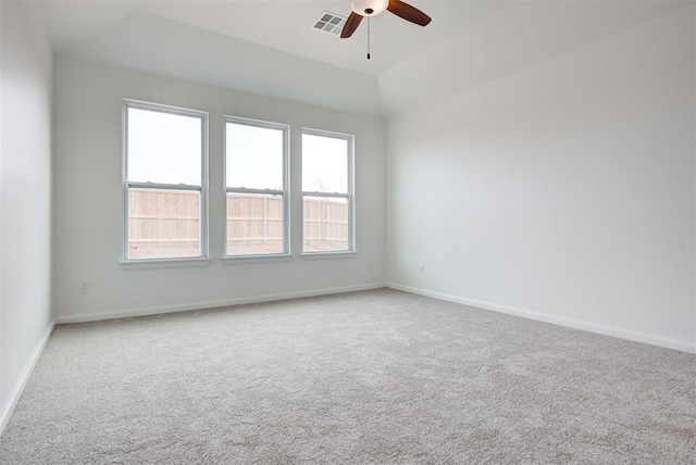 carpeted spare room with visible vents, baseboards, and a ceiling fan