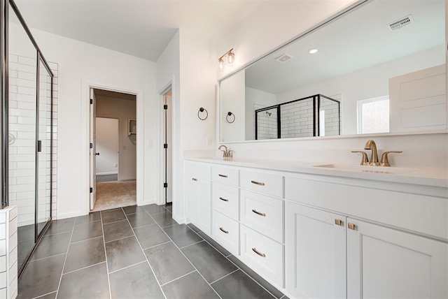 full bath with a stall shower, tile patterned flooring, a sink, and double vanity