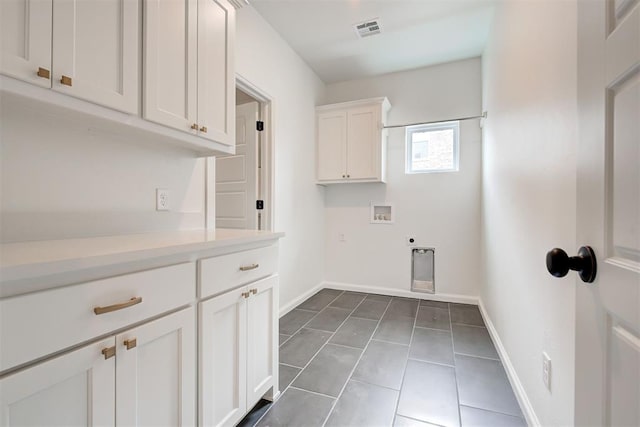 washroom with hookup for a washing machine, visible vents, cabinet space, electric dryer hookup, and baseboards