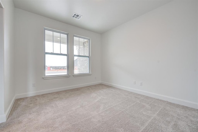 empty room with light carpet, baseboards, and visible vents