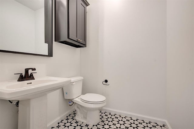 bathroom with a sink, tile patterned floors, toilet, and baseboards