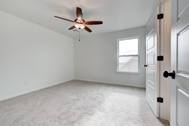 unfurnished room featuring ceiling fan, visible vents, baseboards, and light colored carpet