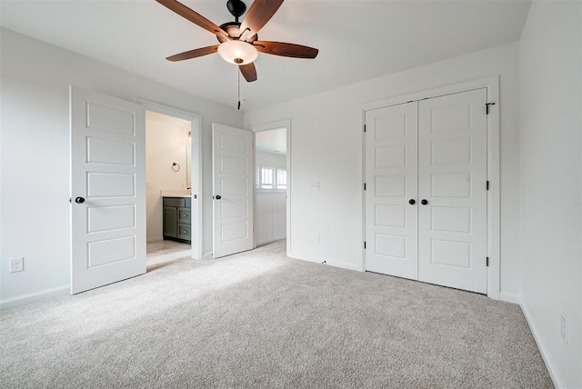 unfurnished bedroom featuring baseboards, a closet, ensuite bath, and light colored carpet