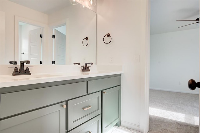 bathroom featuring double vanity, baseboards, a ceiling fan, and a sink