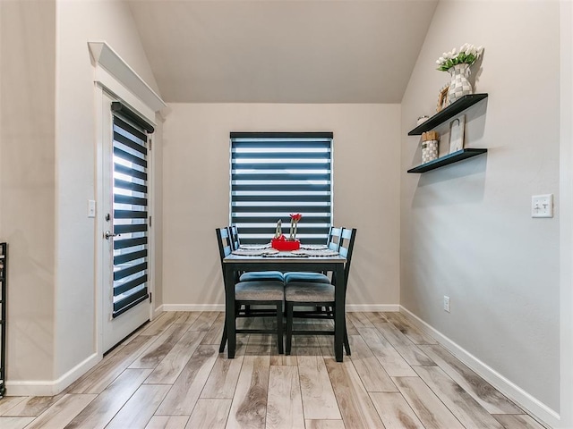 dining room featuring light hardwood / wood-style floors and lofted ceiling