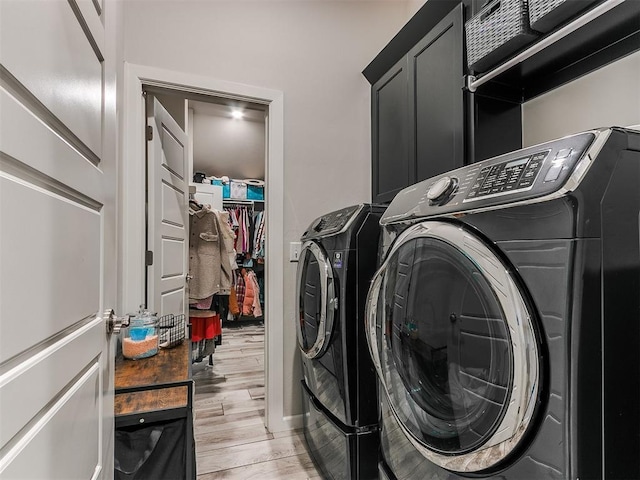 washroom with washer and dryer and light wood-type flooring