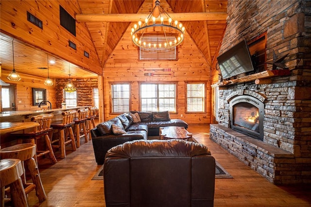 living room with hardwood / wood-style floors, wooden ceiling, rustic walls, and high vaulted ceiling