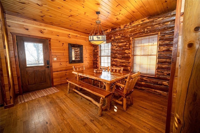 dining area featuring hardwood / wood-style floors, rustic walls, and wood ceiling