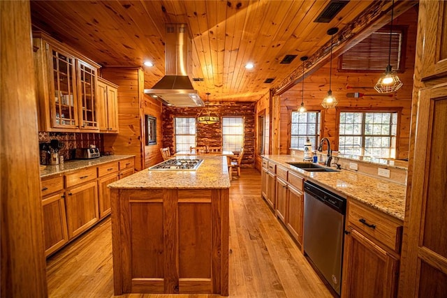 kitchen with sink, log walls, an island with sink, decorative light fixtures, and appliances with stainless steel finishes