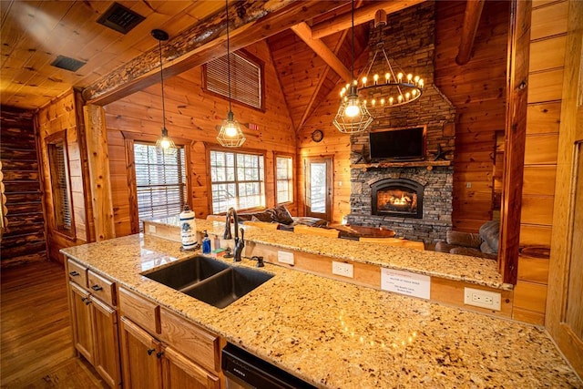 kitchen with light stone countertops, wood ceiling, sink, pendant lighting, and a fireplace