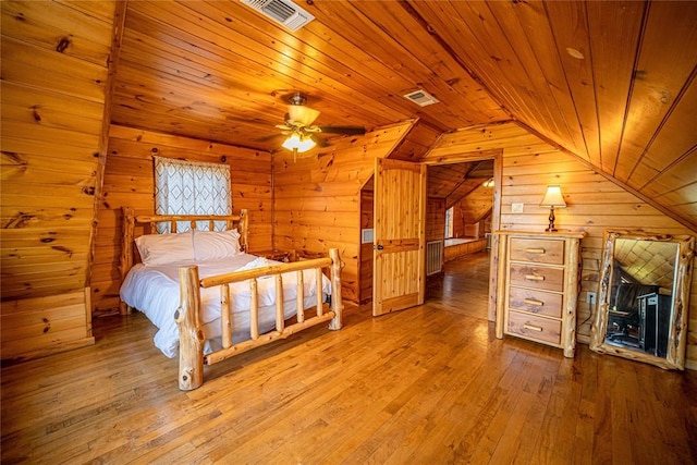 unfurnished bedroom with rustic walls, hardwood / wood-style floors, wooden ceiling, and vaulted ceiling