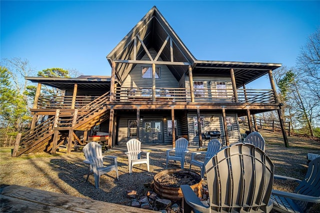 rear view of property with a patio area, a balcony, a deck, and an outdoor fire pit