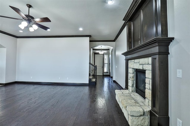 living room featuring a fireplace, dark wood-type flooring, ceiling fan, and ornamental molding