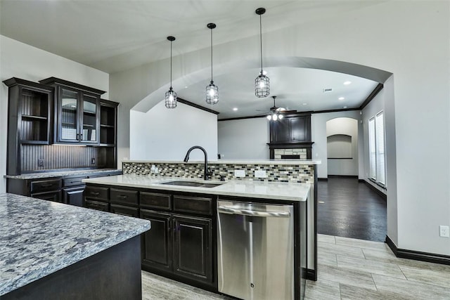 kitchen featuring backsplash, stainless steel dishwasher, ceiling fan, sink, and pendant lighting