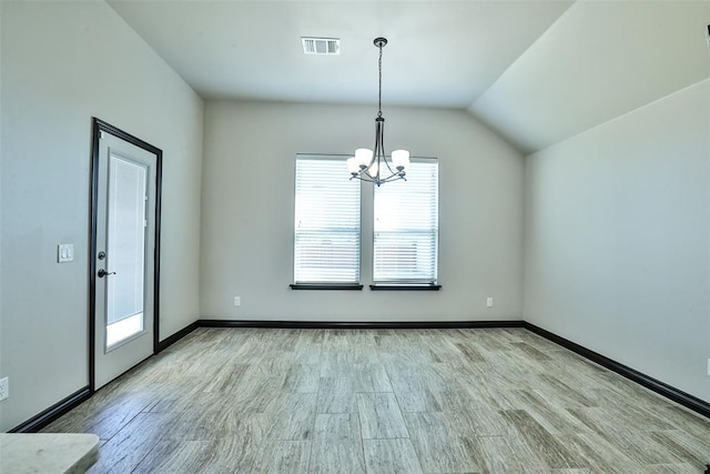 unfurnished dining area with a notable chandelier, vaulted ceiling, and light hardwood / wood-style flooring