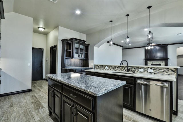 kitchen featuring decorative backsplash, sink, pendant lighting, dishwasher, and a center island