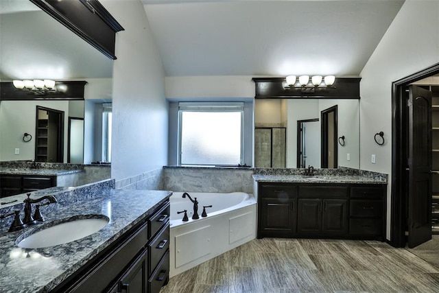 bathroom with hardwood / wood-style flooring, vanity, independent shower and bath, and vaulted ceiling