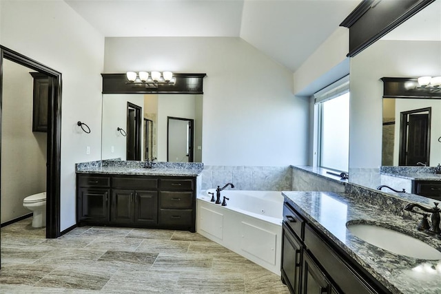 bathroom featuring vanity, a chandelier, lofted ceiling, toilet, and a bathing tub