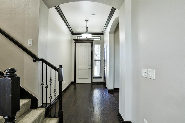 foyer with ornamental molding and dark wood-type flooring