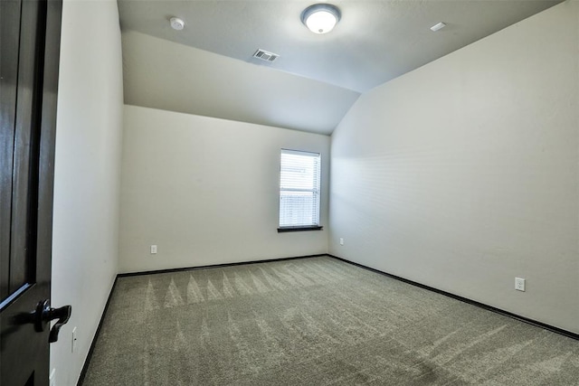 empty room featuring carpet floors and vaulted ceiling