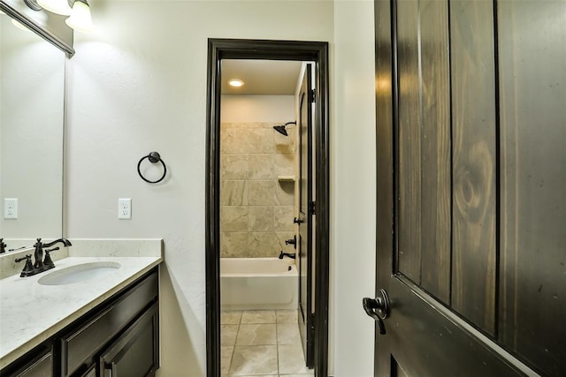 bathroom featuring tile patterned flooring, tiled shower / bath combo, and vanity