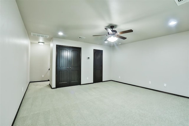 unfurnished bedroom featuring light carpet and ceiling fan