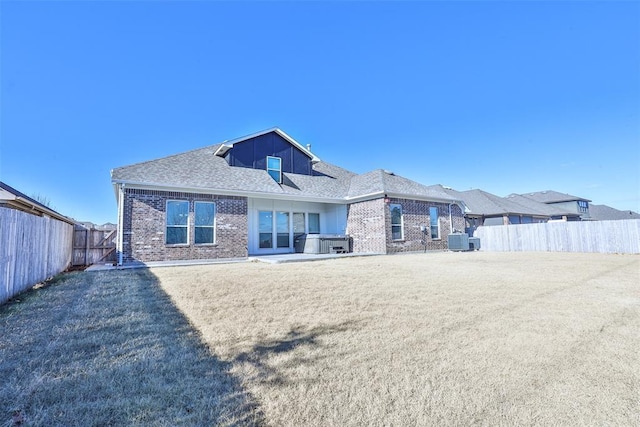 back of house featuring central AC and a hot tub