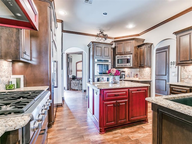 kitchen featuring custom exhaust hood, a center island, backsplash, crown molding, and appliances with stainless steel finishes