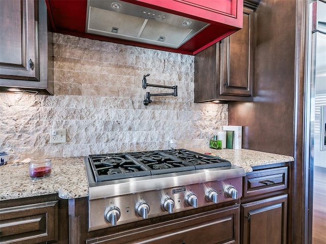 kitchen with decorative backsplash, dark brown cabinets, and stainless steel gas stovetop