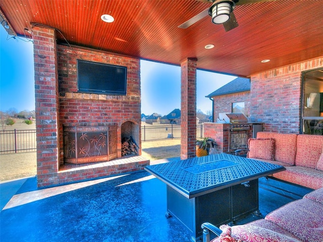 view of patio / terrace with an outdoor living space with a fireplace, ceiling fan, a grill, and an outdoor kitchen