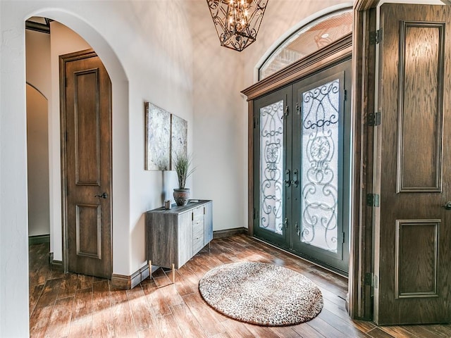 entrance foyer featuring a chandelier, french doors, and wood-type flooring