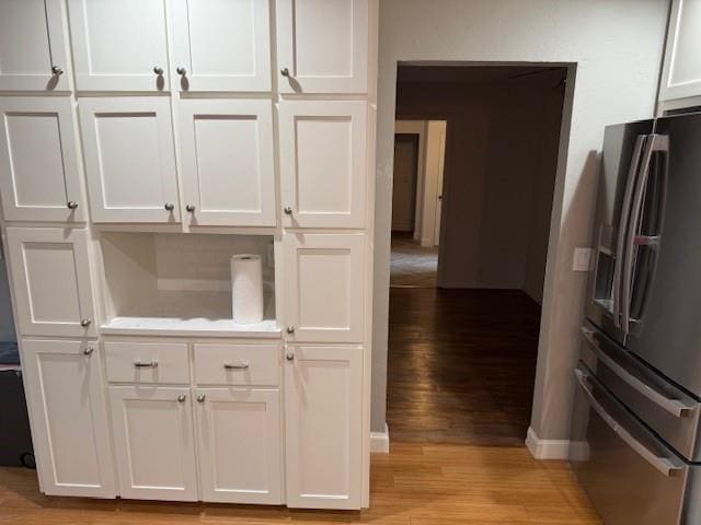 kitchen featuring appliances with stainless steel finishes, light hardwood / wood-style flooring, and white cabinetry