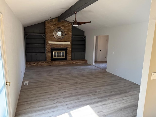 unfurnished living room with a brick fireplace, vaulted ceiling with beams, and light wood-type flooring