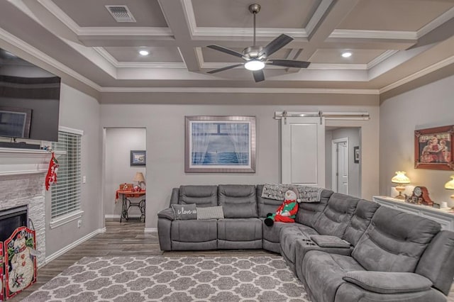 living room with beamed ceiling, ornamental molding, a barn door, and coffered ceiling