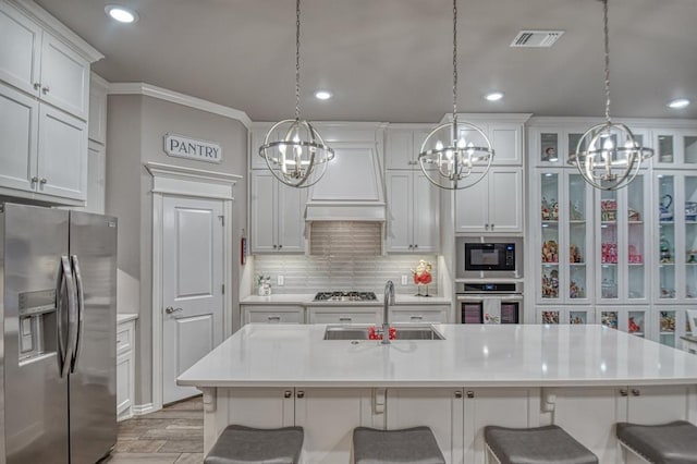 kitchen featuring an island with sink, stainless steel appliances, a breakfast bar area, and sink