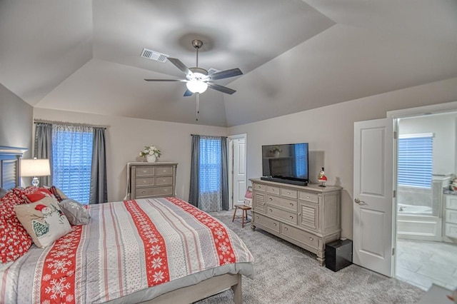 bedroom featuring ceiling fan, light colored carpet, ensuite bathroom, and vaulted ceiling