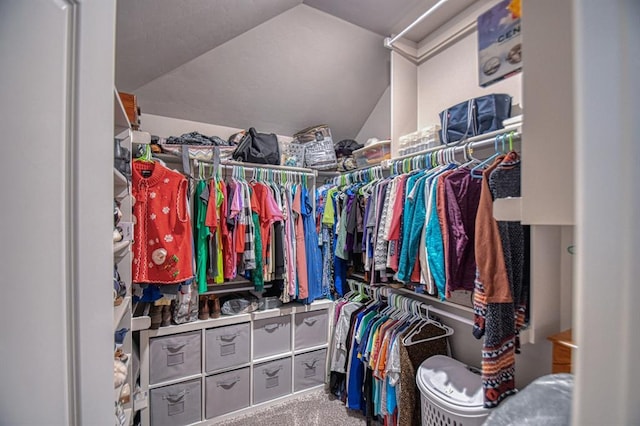 walk in closet featuring carpet floors and vaulted ceiling