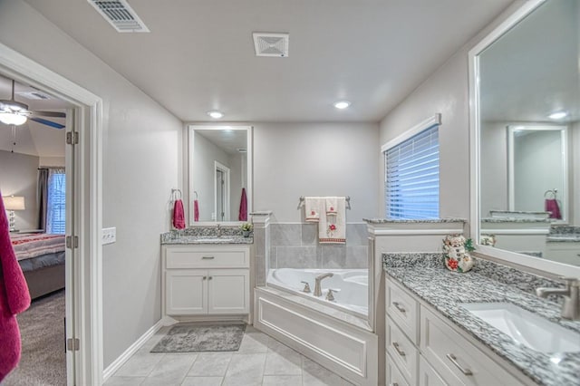 bathroom featuring tile patterned floors, vanity, ceiling fan, and a bathtub