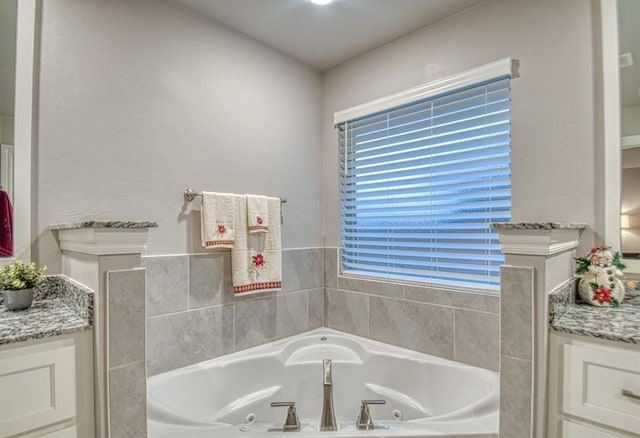 bathroom with a bath, vanity, and a wealth of natural light