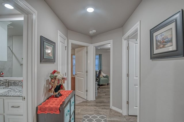 hallway with light hardwood / wood-style flooring and sink