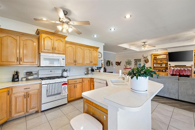 kitchen with kitchen peninsula, white appliances, ceiling fan, sink, and light tile patterned floors