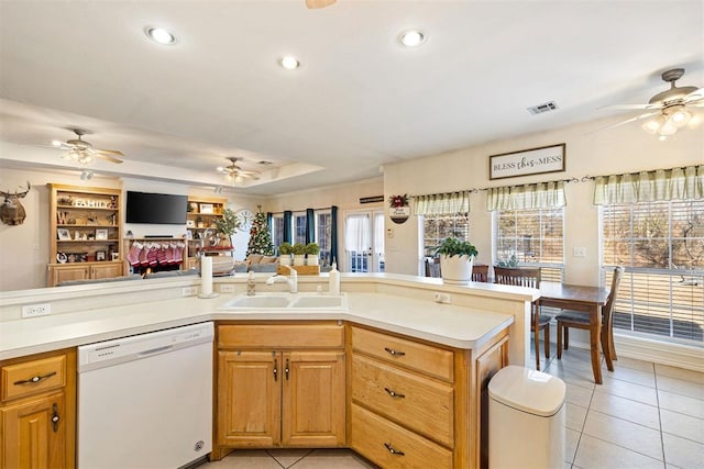 kitchen with light tile patterned floors, white dishwasher, a raised ceiling, and sink