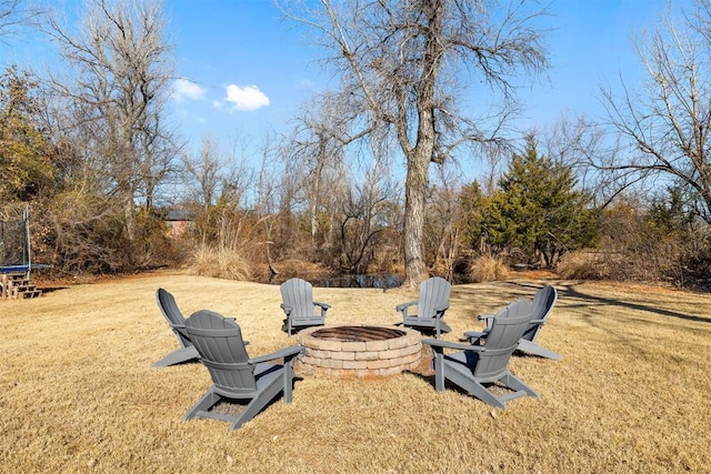 view of yard with a fire pit and a trampoline